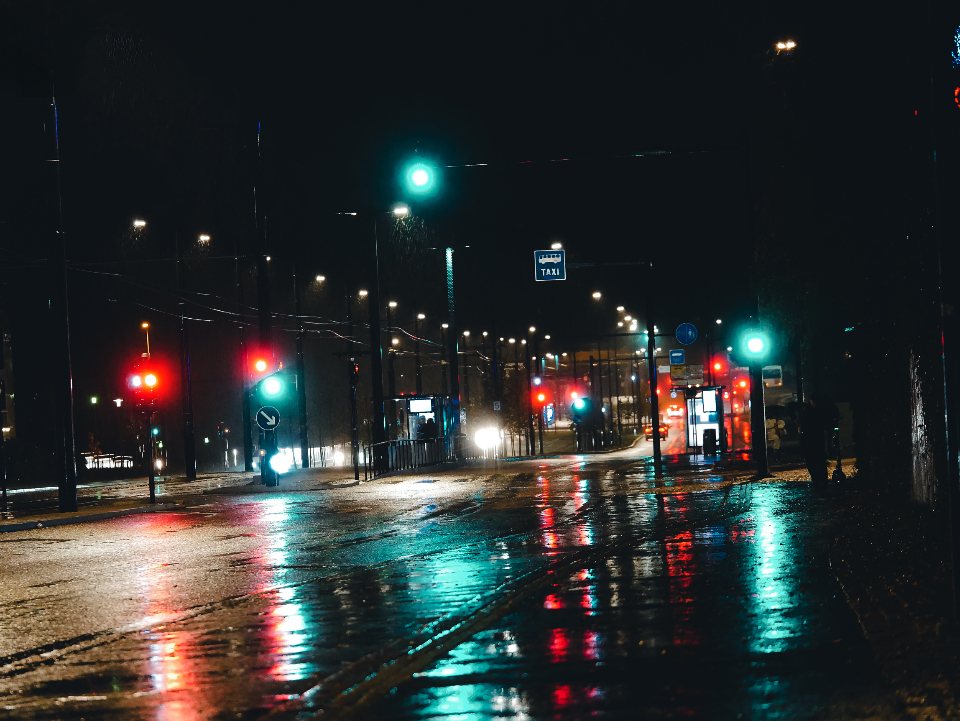 A rain-soaked night street and traffic lights