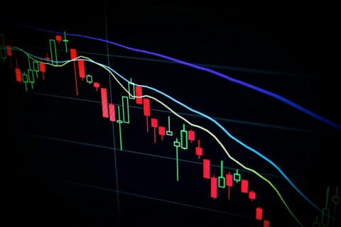 Stock chart with red bars and lines on a black screen