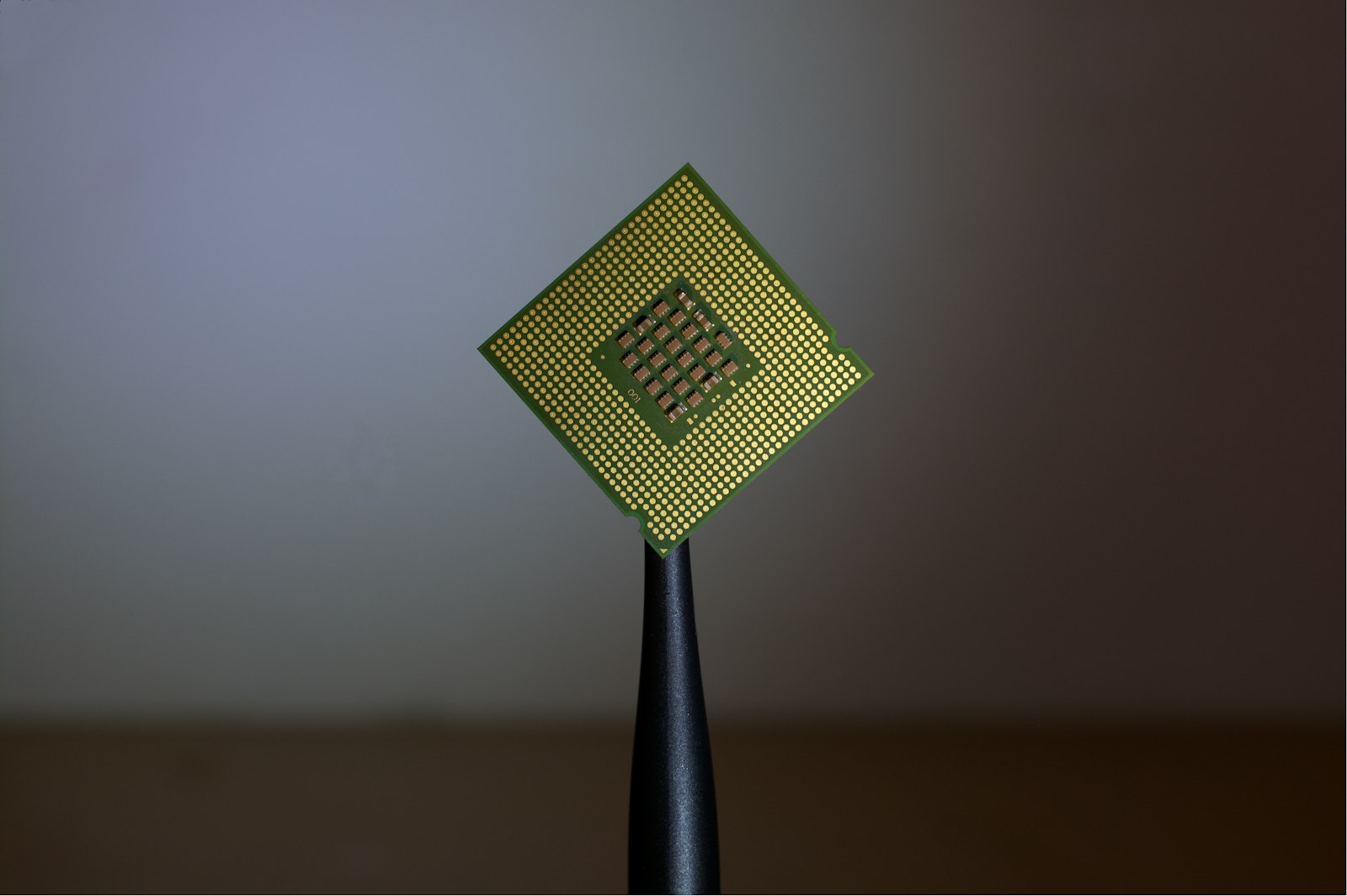 Golden semiconductor chip held with tweezers